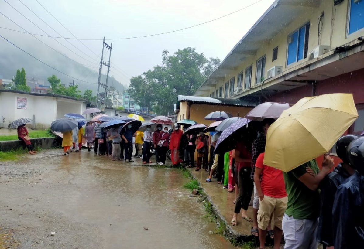 बुटवलमा कोभिड विरुद्धको खोप लगाउन छाता ओढेर पालो कुर्दै (तस्वीरहरु)
